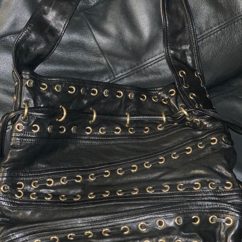 Kooba black leather bag with grommets.